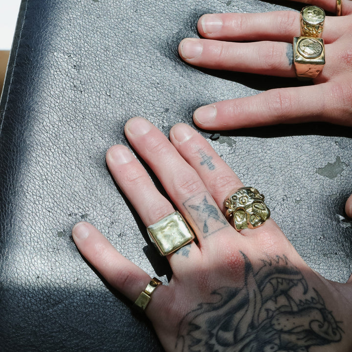 Hands with gold rings on a textured surface