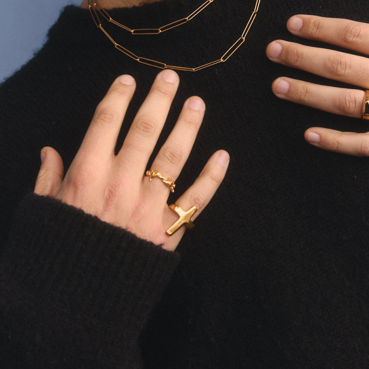 Close-up of a hand wearing gold rings on a black background