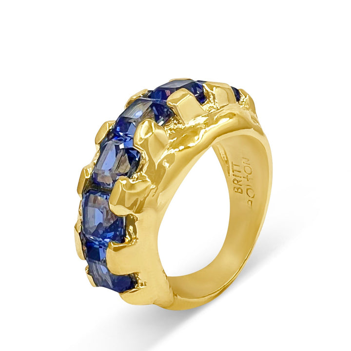 Gold ring with blue gemstones on a white background