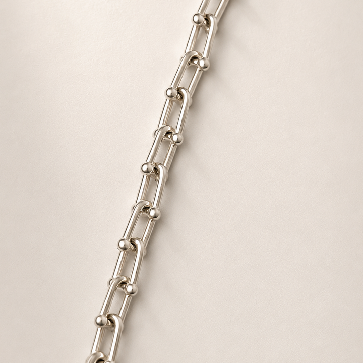Silver chain necklace on a beige background