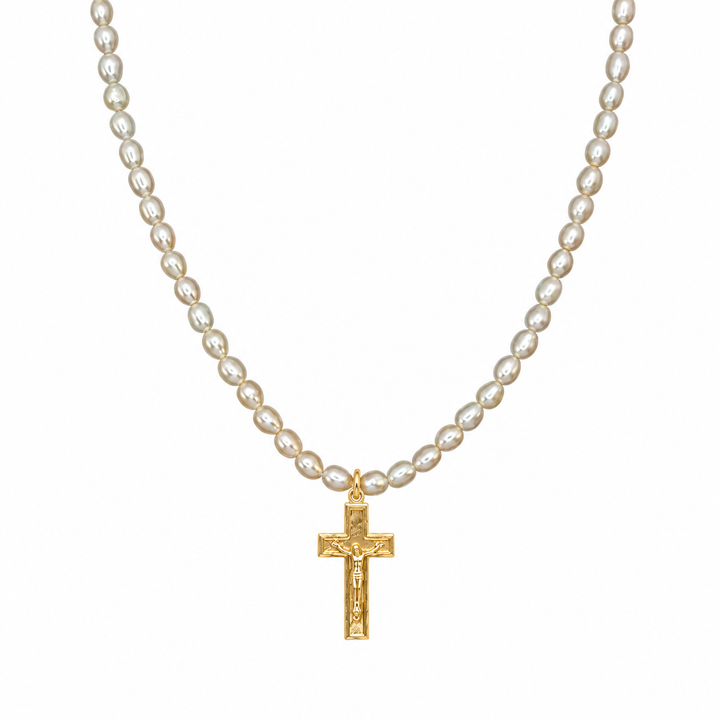 A gold crucifix pendant necklace with a strand of small, lustrous white pearls, shown against a plain white background.