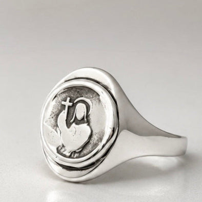 Silver ring with a circular design on a light gray background