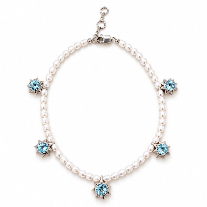 A pearl necklace with five star-shaped silver settings, each holding a light blue gemstone, displayed on a clean white background.