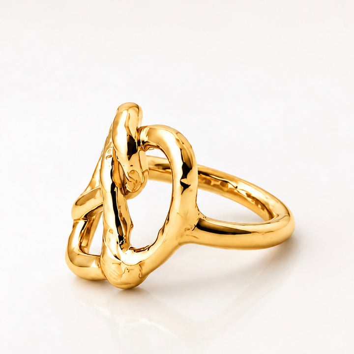 A polished gold ring with an organic, intertwined knot-like design, photographed on a clean white background.