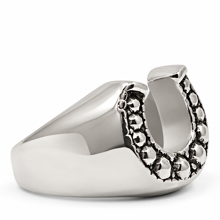 A polished silver-tone signet ring featuring a decorative horseshoe-shaped side embellishment with raised circular details, shown on a clean white background.