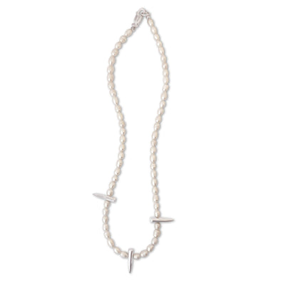Pearl necklace with silver pendants on a white background