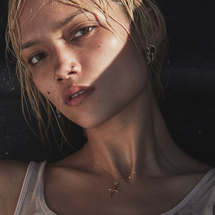 Close-up of a person with a necklace against a dark background