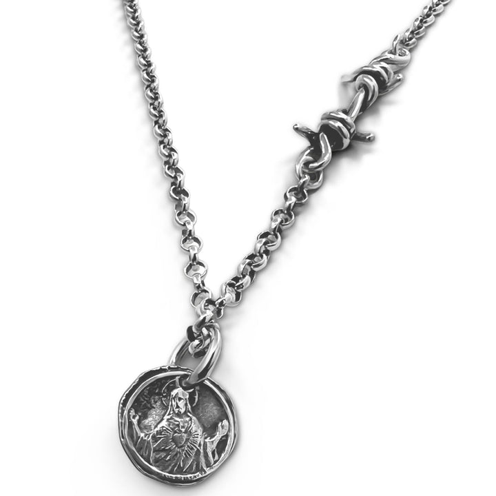 Silver necklace with a round pendant on a white background