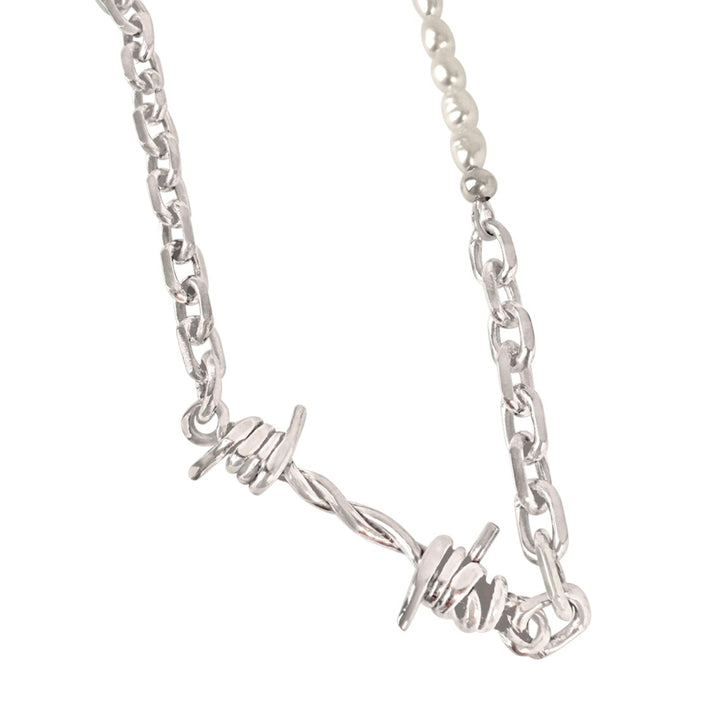 Silver necklace with a barbed wire design on a white background