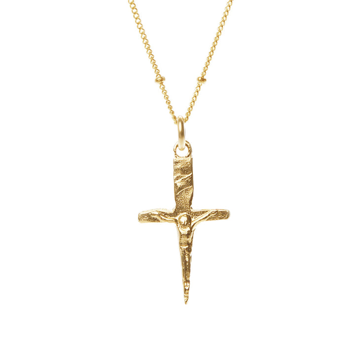 Gold cross pendant necklace on a white background