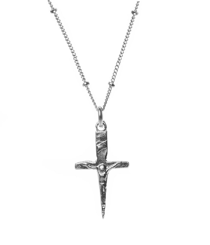 Silver cross pendant necklace on a white background