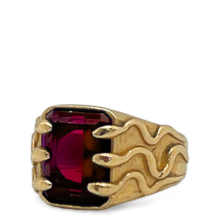 Gold ring with a red gemstone on a white background