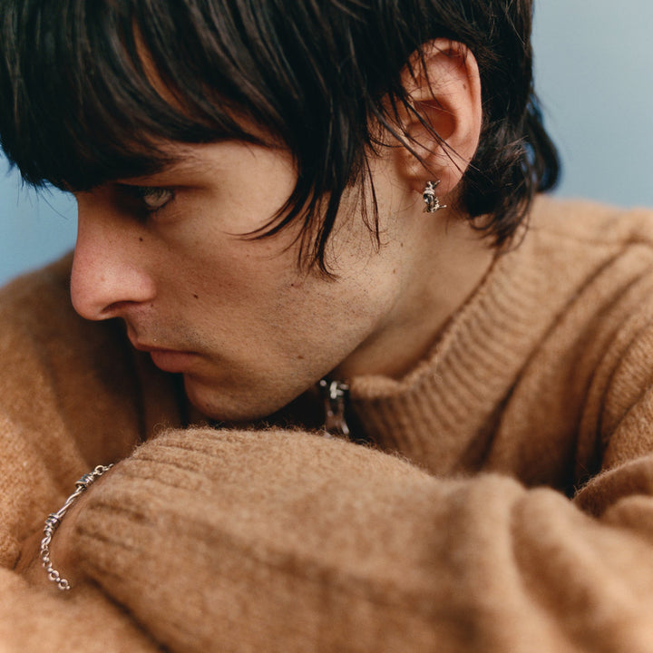 Close-up of a person wearing a brown sweater with a blurred background