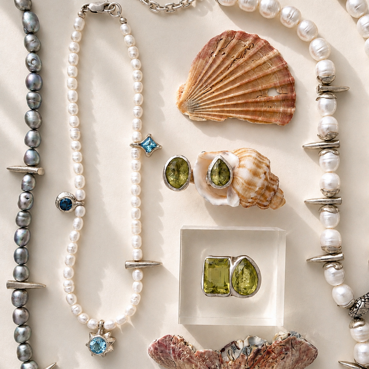 Pearl necklaces, shell earrings, and gemstone earrings on a light background