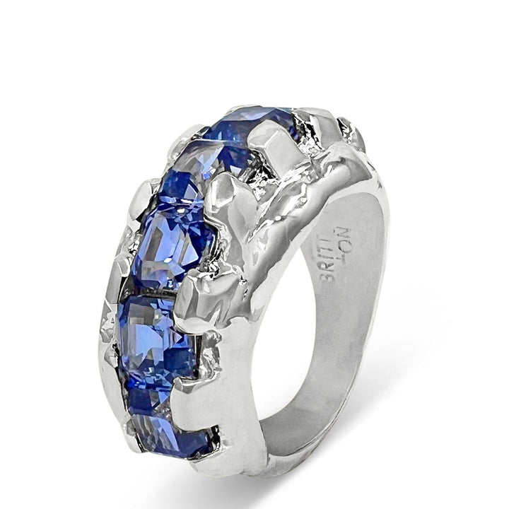 Silver ring with blue gemstones on a white background