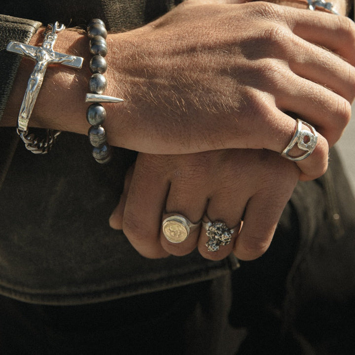 hand wearing our oval signet ring cast with 14k yellow gold holy coin
