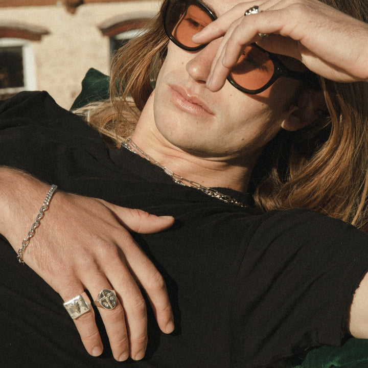 male model laying down, wearing our half & half chain bracelet