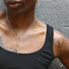 male model wearing two snake pendant necklaces