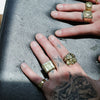 Hands with gold rings on a textured surface