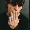 Person wearing two rings on their finger with a dark background