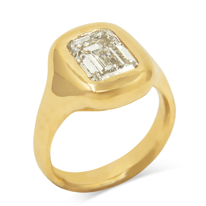 A hand carved smooth & glossy signet style ring with a bubbly feel, cast in 14k Yellow Gold with an Emerald cut Lab grown Diamond.