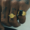 Hand with tattoos wearing two rings on a white background