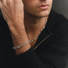 Man wearing a silver bracelet with a subtle design