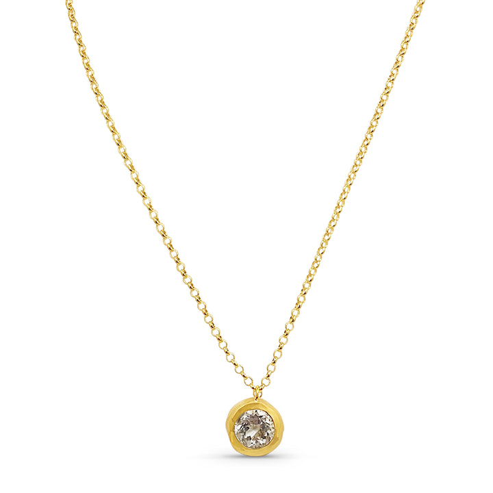 Gold necklace with a round pendant on a white background
