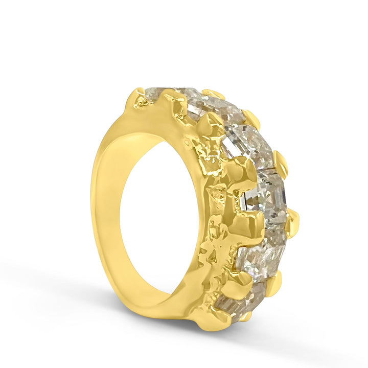 Gold ring with embedded stones on a white background