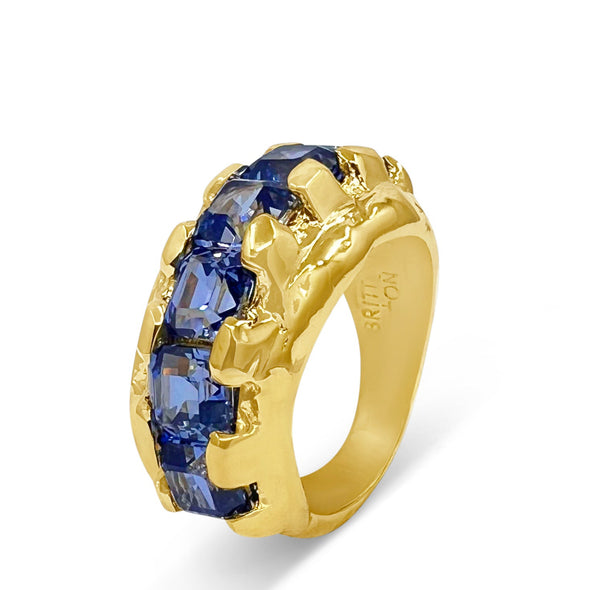 Gold ring with blue gemstones on a white background