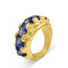 Gold ring with blue gemstones on a white background