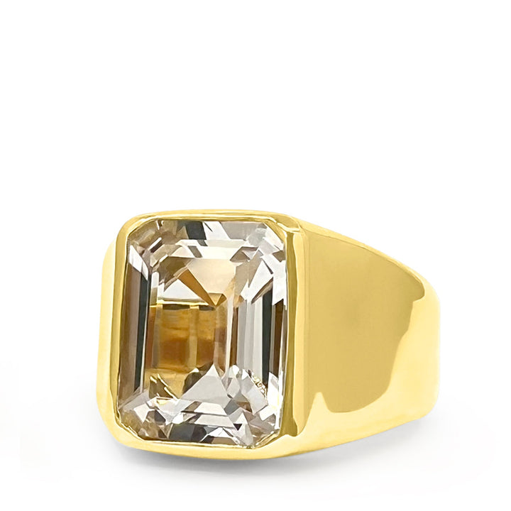Gold ring with a large rectangular gemstone on a white background