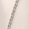 Silver chain necklace on a beige background