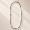 Silver chain necklace on a white plate