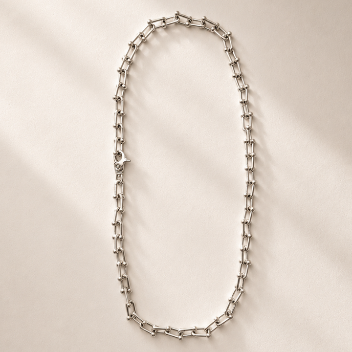 Silver chain necklace on a white plate
