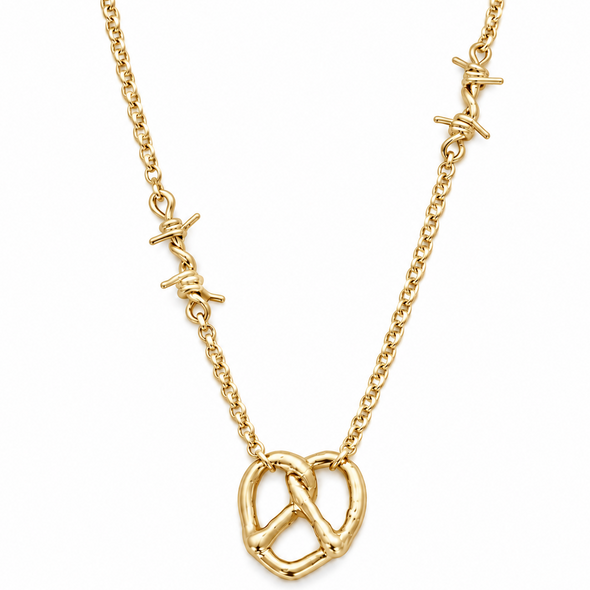 A gold necklace featuring a central pretzel-shaped pendant and three small barbed wire charms along the chain, displayed on a clean white background.