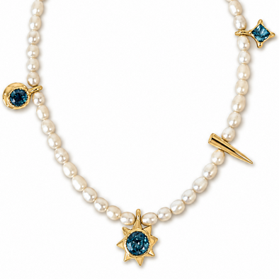 A gold and pearl necklace featuring a central gold starburst with a deep blue gemstone, flanked by smaller gold star and crescent moon charms with matching blue stones, all on a clean white background.