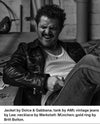 Man wearing Dolce & Gabbana jacket and AMI tank top in a black and white setting.