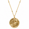 A gold coin pendant necklace featuring an embossed religious figure holding a cross, suspended from a delicate gold chain on a solid white background.