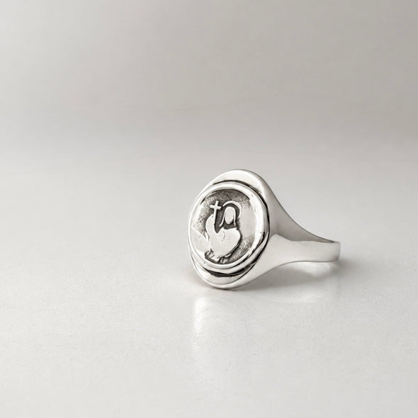 Silver ring with a circular design on a light gray background