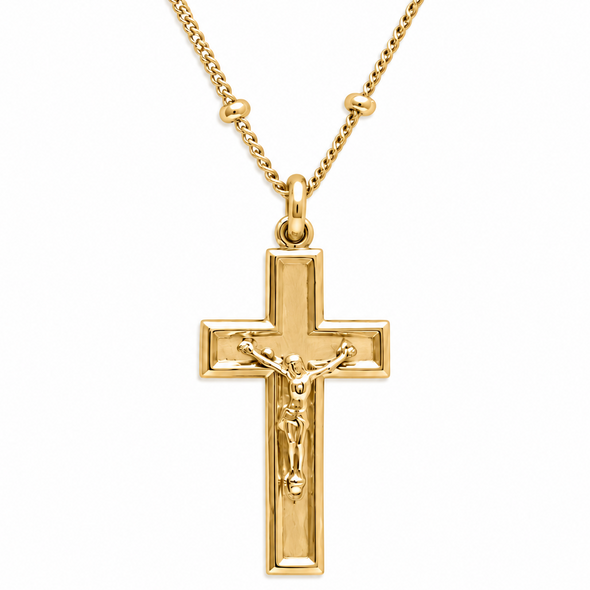 A gold cross pendant necklace featuring a detailed crucifix with Jesus Christ on a polished chain, set against a plain white background.