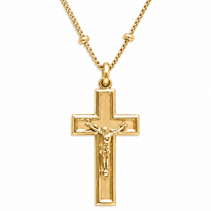 A gold cross pendant necklace featuring a detailed crucifix with Jesus Christ on a polished chain, set against a plain white background.