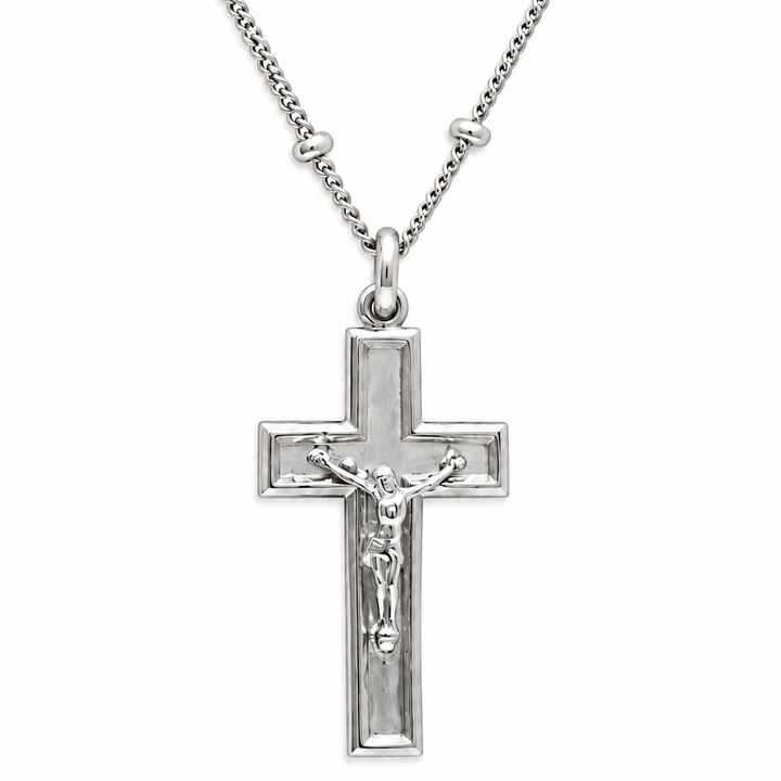 Silver crucifix pendant necklace with a detailed corpus on a polished cross, suspended from a matching chain on a white background.