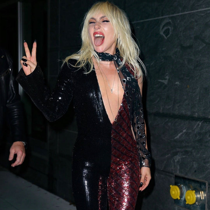 Person in a black and red sequin outfit with a dark background