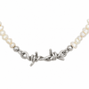 A close-up of a necklace featuring irregular white freshwater pearls and a polished silver-tone barbed wire clasp, shown against a plain white background.