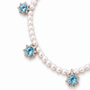 A pearl necklace with silver starburst charms, each featuring a round light blue gemstone, shown on a clean white background.