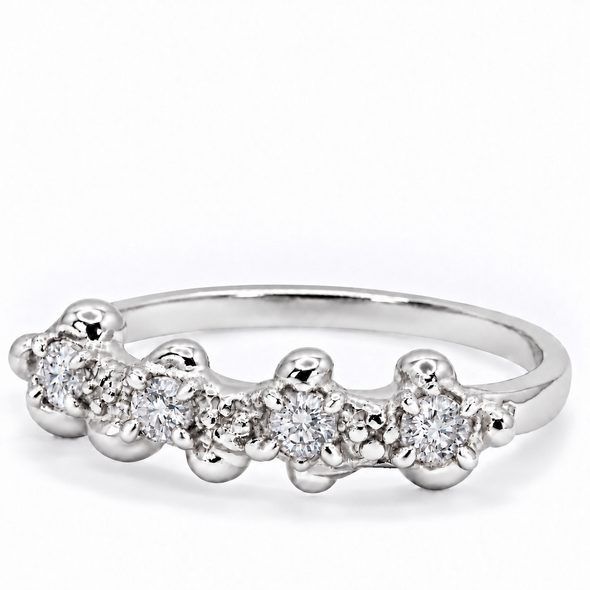 A silver band ring featuring a row of small clear gemstones in a beaded, flower-like setting, photographed on a clean white background.