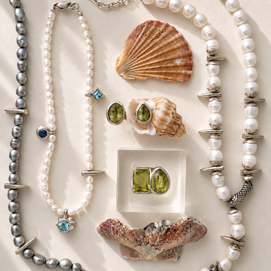 Pearl necklaces, shell earrings, and gemstone earrings on a light background