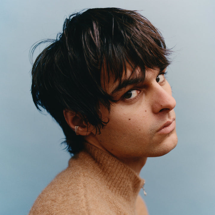 Person with dark hair and a light background