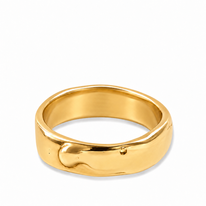A polished yellow gold ring with a unique, organic wavy shape and a small raised dot detail on the front, shown on a clean white background.